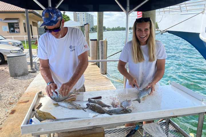 a man and a woman standing next to a fence